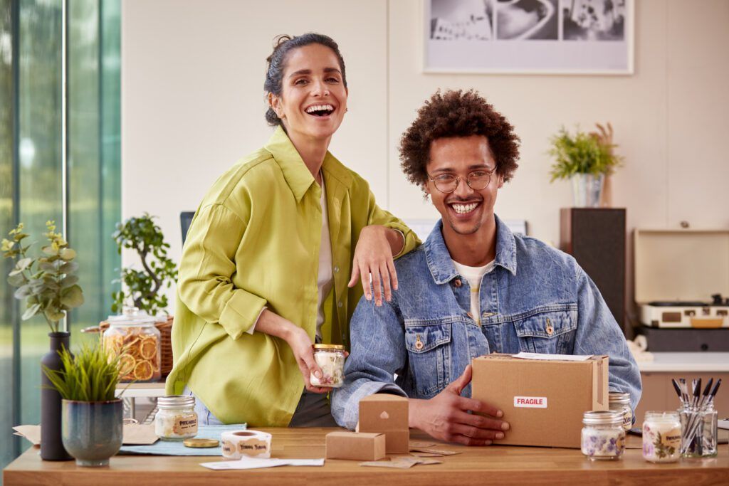Smiling man and woman, holding a box of Promo Products together in Edmonton, AB