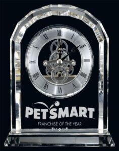 Clear crystal Centura clock with exposed inner gears, Roman numerals, and engraved base displayed in Alberta, CA